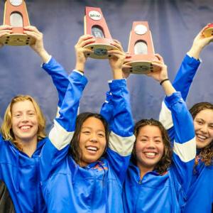 波莫纳-推荐十大正规网赌网站女子游泳和跳水队微笑着把NCAA的奖杯举过头顶.